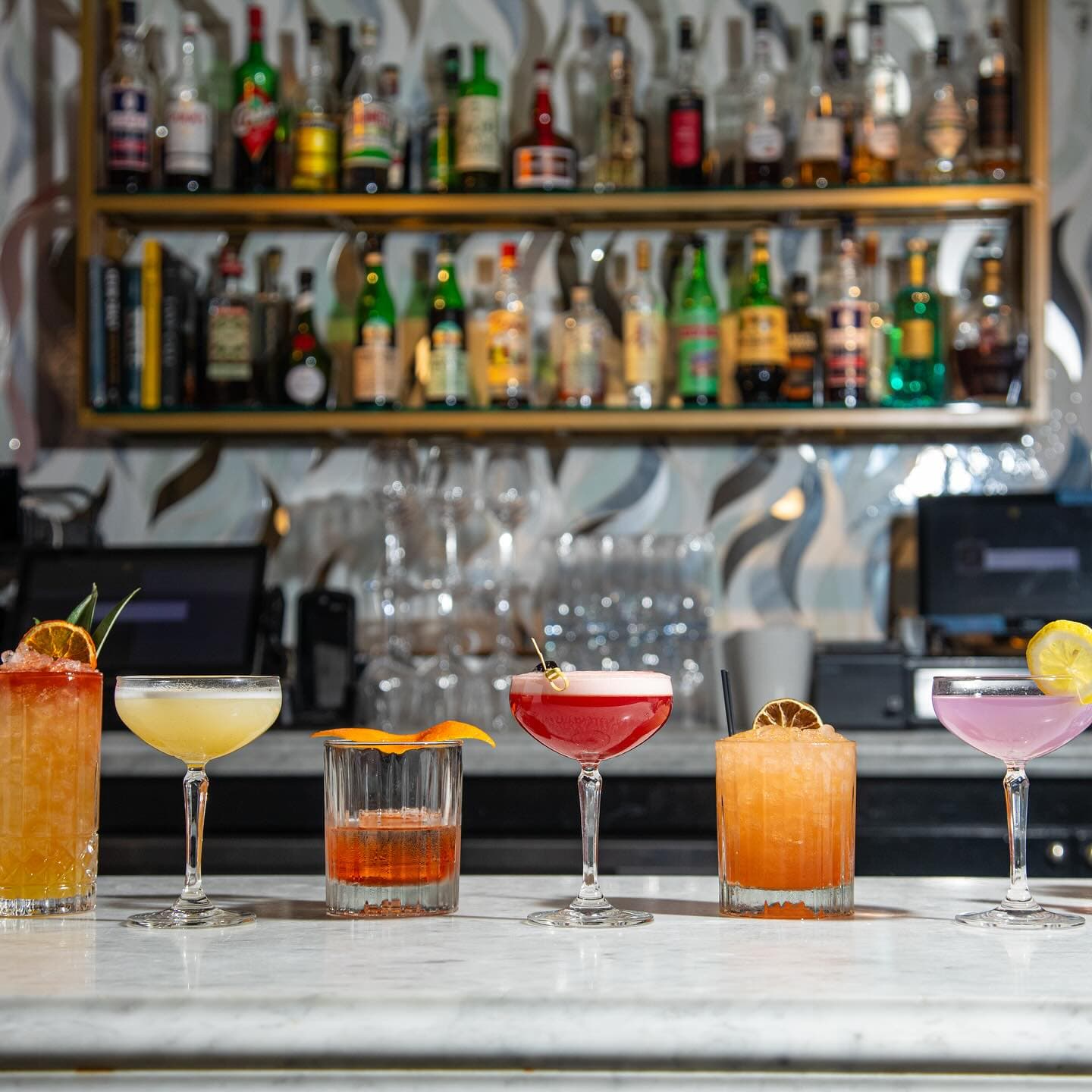 A vibrant lineup of handcrafted cocktails at Sofia NOLA showcases the bar’s creativity and elegance—each drink artfully presented against a chic, modern backdrop, inviting guests to sip and savor in true New Orleans style.