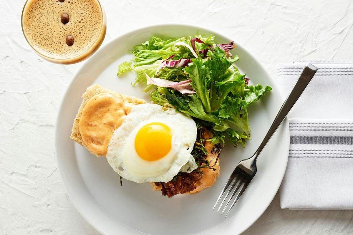 Breakfast sandwich with a fried egg and greens